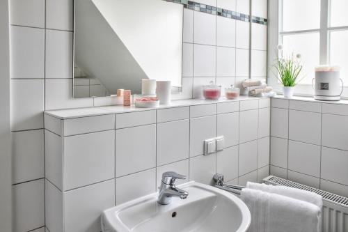 a white bathroom with a sink and a mirror at Schloß Falkenhaus in Bad Berneck im Fichtelgebirge