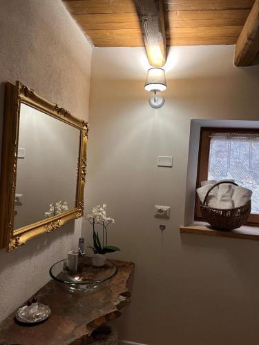 een badkamer met een spiegel, een wastafel en een raam bij B&B Il Gufo in Erto