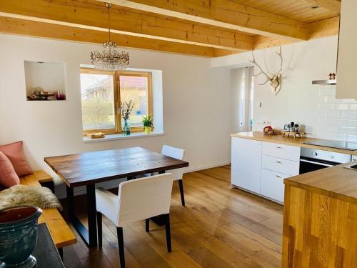 a kitchen with a wooden table and a dining room at Urlaub im Grünen - wunderschönes Bauernhaus in Bad Waltersdorf