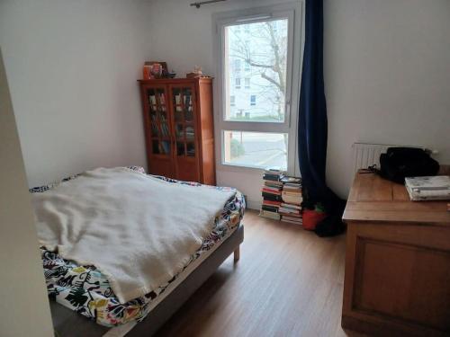 une chambre avec un lit, une commode et une fenêtre dans l'établissement Appartement proche Paris, à Le Pré-Saint-Gervais