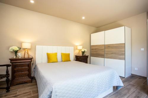 una camera da letto con un grande letto bianco con cuscini gialli di Quinta Santo Antonio a Gouveia