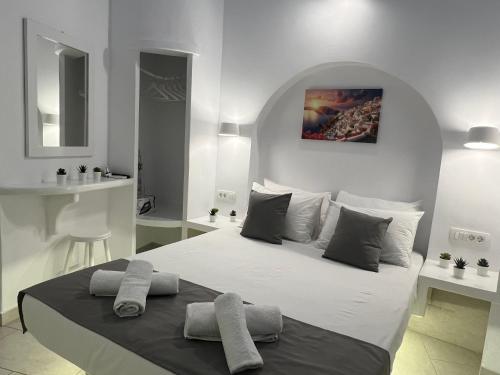 a white bedroom with a large bed with two pillows at Villa Pavlina in Karterados
