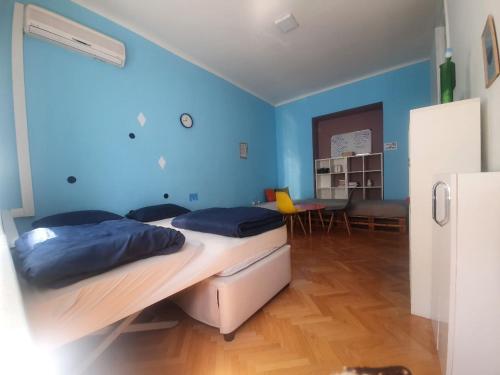 2 camas en una habitación con paredes azules en Eternal Fire old town en Sarajevo
