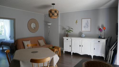 un salon avec une table et un canapé dans l'établissement Gîtes de Neyrac, appartement Violette - piscine, rivière à 100 m, vue sur les collines, à Meyras