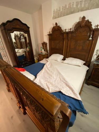 a bedroom with two wooden beds and a mirror at appartamenti con terrazo solare in Perugia