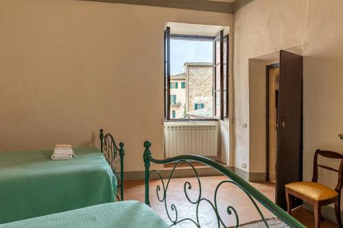 um quarto com uma cama verde e uma janela em Palazzo Costanti - A 8 minuti dalle terme em San Quirico dʼOrcia
