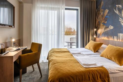 una camera d'albergo con letto, scrivania e finestra di Dom Wczasowy Zew Morza a Jastrzębia Góra