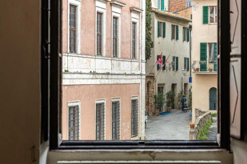 uma vista para um beco a partir de uma janela em Palazzo Costanti - A 8 minuti dalle terme em San Quirico dʼOrcia
