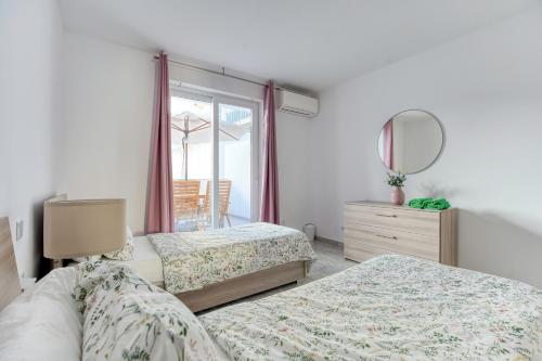 a bedroom with two beds and a mirror at Brand New 2 Bed 2 Bath Apartment In Sliema By The Sea in Sliema