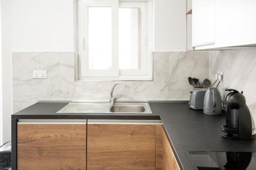 een keuken met een wastafel en een aanrecht bij Brand New 2 Bed 2 Bath Apartment In Sliema By The Sea in Sliema
