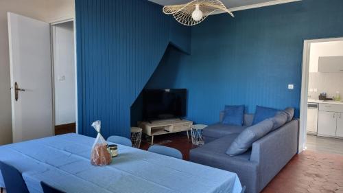 - un salon avec des murs bleus et un canapé bleu dans l'établissement Charmant petit gîte au cœur de la Baie de Somme, à Saigneville