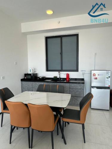 a dining room with a table and chairs and a refrigerator at Urban Suites @ George Town Penang by BNB4U in George Town