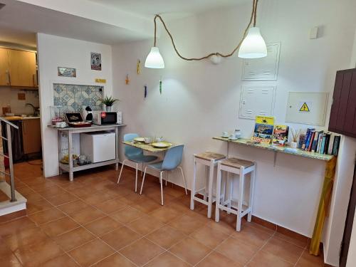 a kitchen with a counter and a table and chairs at B&B do Paço in Lagos