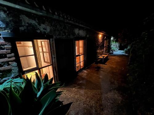 um quarto escuro com três janelas e um edifício em Casa Jardín Tropical em Los Llanos de Aridane