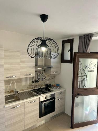 a kitchen with a stove and a chandelier at La Cupola - casa vacanze n 10 in Termini Imerese
