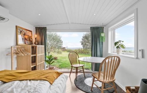 Cozy Home In Esbjerg V With Wifi في إيسبيرغ: غرفة نوم بسرير وطاولة وكراسي