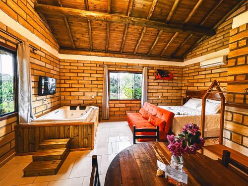 a room with a tub and a bed and a table at Pousada Equilíbrio dos Canyons in Praia Grande