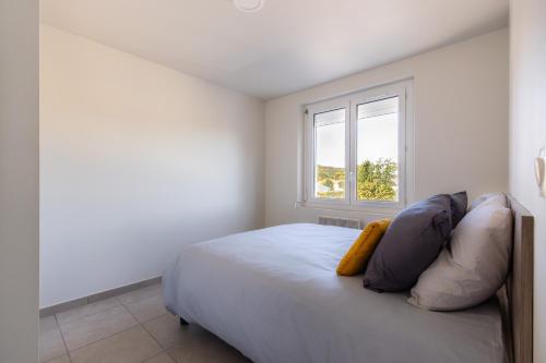 une chambre blanche avec un lit et une fenêtre dans l'établissement LE PROVENCE, à Malijai