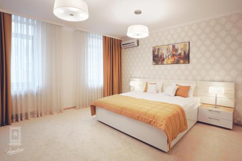 a bedroom with a large bed with a yellow blanket at Familion ApartHotel in Chişinău