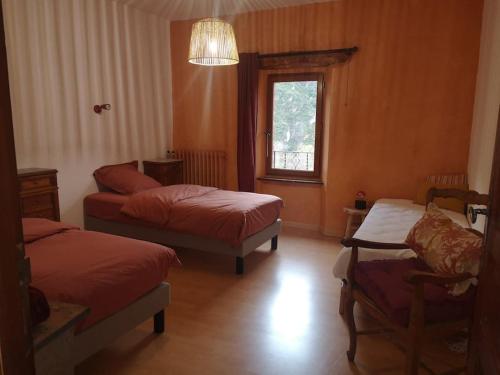 une chambre avec deux lits et un canapé et une fenêtre dans l'établissement Au coeur des vignes, entre montagnes et rivière, à Vieussan