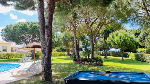 a pool table in front of a yard with trees at Bicos 303 - Shared Pool - 6 Guests - Albufeira in Albufeira