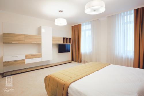 a bedroom with a bed and a flat screen tv at Familion ApartHotel in Chişinău