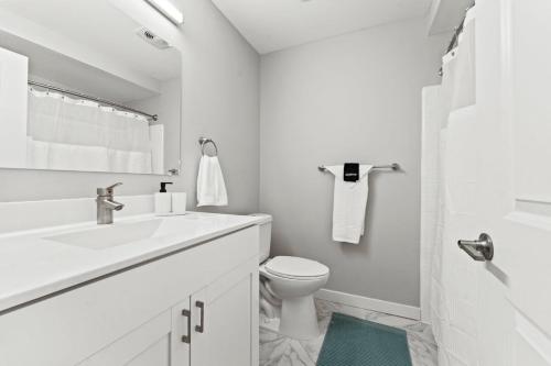 Baño blanco con lavabo y aseo en Serene 2 Bedroom Retreat in Rochester Hills, en Rochester Hills