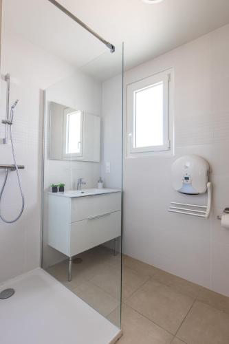 une salle de bain blanche avec un lavabo et une douche dans l'établissement LE PROVENCE, à Malijai