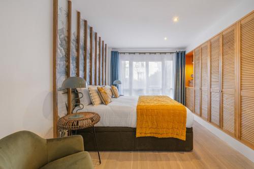 - une chambre avec un lit doté d'une couverture jaune et d'une chaise dans l'établissement Soubise, à Paris