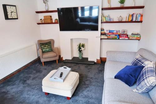 Una sala de estar con un sofá y un televisor de pantalla plana. en Castle Manor, 4 Bed Seaside Retreat, en Scarborough