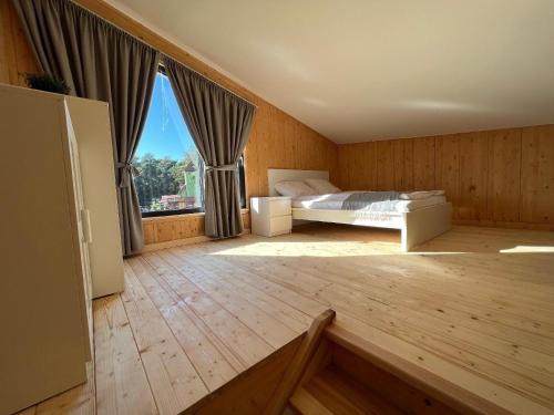 a bedroom with a bed and a large window at Nettes Ferienhaus in Pustkowo mit Eigener Terrasse in Pustkowo