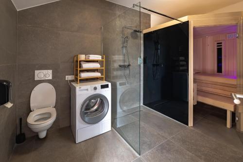 a bathroom with a washing machine and a shower at Apartments Luxury AD in Jesenice