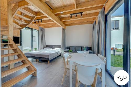 a room with a bed and a table and chairs at Nettes Ferienhaus in Pustkowo mit Eigener Terrasse in Pustkowo