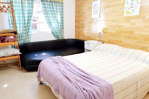 a bedroom with a bed and a black leather couch at Villawolf Casa para 5 personas in Federación