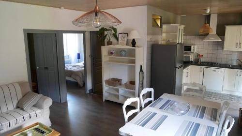 Il dispose d'une cuisine et d'un salon avec une table et un réfrigérateur. dans l'établissement Gîtes de Neyrac, appartement Rose - piscine, rivière à 100 m, vue sur les collines, à Meyras