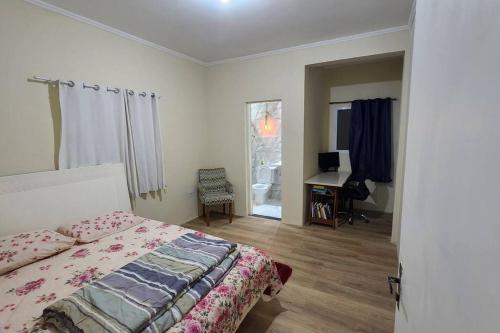 - une chambre avec un lit et un bureau dans l'établissement Casa com piscina Embu-Guaçu/ Itapecerica (Chácara), à Embu-Guaçu