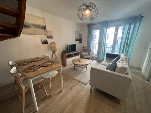 un salon avec un canapé et une table dans l'établissement Beau T3 - Stationnement privé, à Toulouse