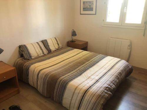 une chambre avec un lit, une lampe et une fenêtre dans l'établissement Toulon - CAP BRUN - T3 rez de jardin, à Toulon