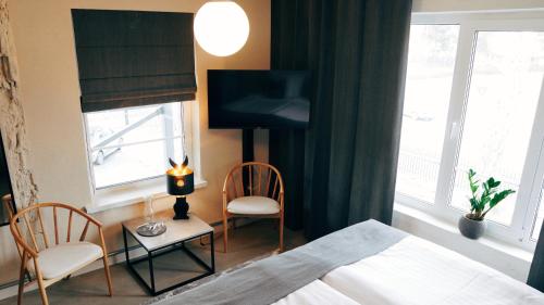 sypialnia z łóżkiem, 2 krzesłami i telewizorem w obiekcie Loft Hotel Rauma w mieście Rauma