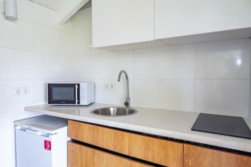 a kitchen with a sink and a microwave at Bed & Bike Westpunt in Westpunt