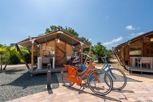 two bikes parked in front of a cabin at Bed & Bike Westpunt in Westpunt
