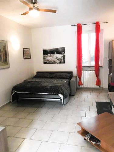a bedroom with a bed and red curtains at La casetta di Sofia in Moneglia