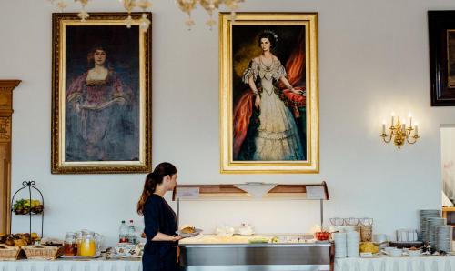a woman standing in front of a painting in a museum at Hotel Wilder Mann in Passau