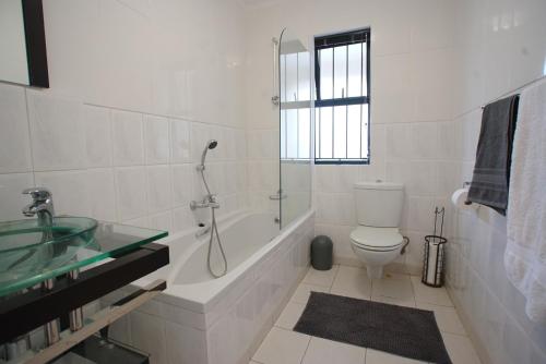 a bathroom with a shower and a toilet and a sink at Kritzie's Corner - Central and Family Friendly in Cape Town