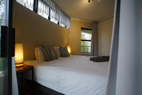 a bedroom with a white bed and a window at Kritzie's Corner - Central and Family Friendly in Cape Town