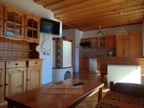 a kitchen with wooden cabinets and a table and a tv at Pension Sedlak in Millstatt