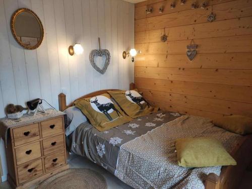 une chambre avec un lit et un mur en bois dans l'établissement les marmottes, à Gérardmer