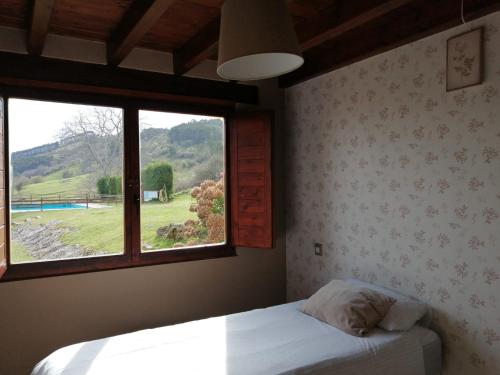 a bedroom with a bed and a large window at Alcabala del Viento in Noriega