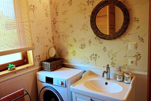 a bathroom with a washing machine and a sink at Dom wakacyjny w kratkę & spa in Białogóra