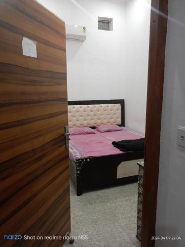 a bedroom with a bed and a wooden door at Radheshyam bhawan in Govardhan